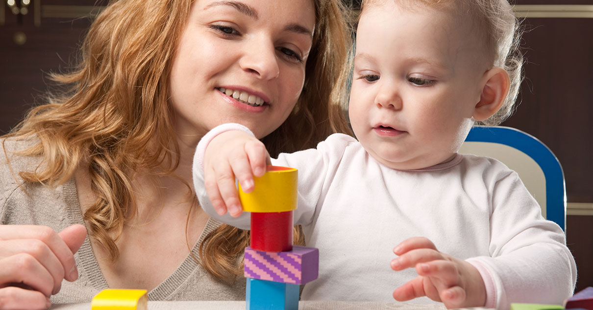 Baby and caregiver with blocks